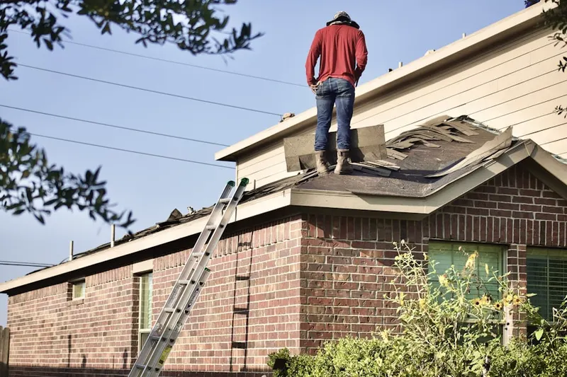Professional roofer working on a residential roof in Little Falls